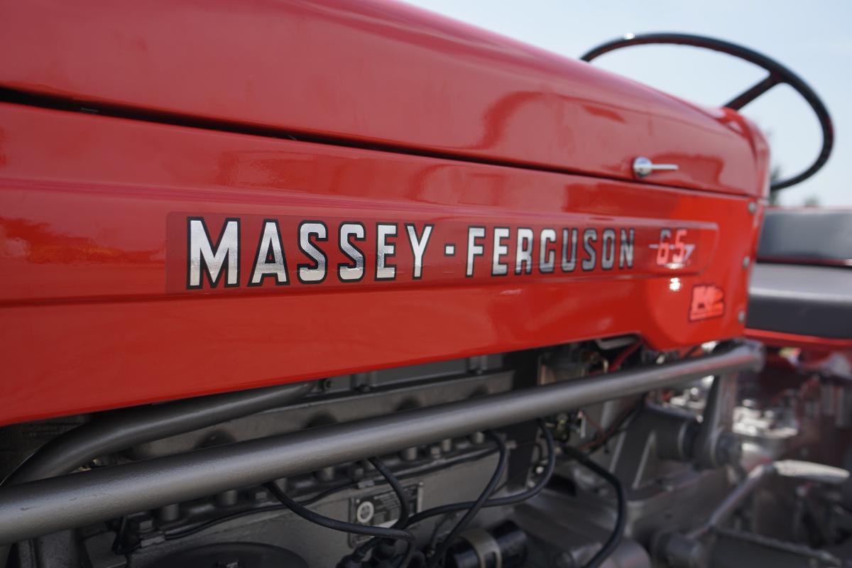 The words Massey-Ferguson 65 appear on the side of a red tractor.