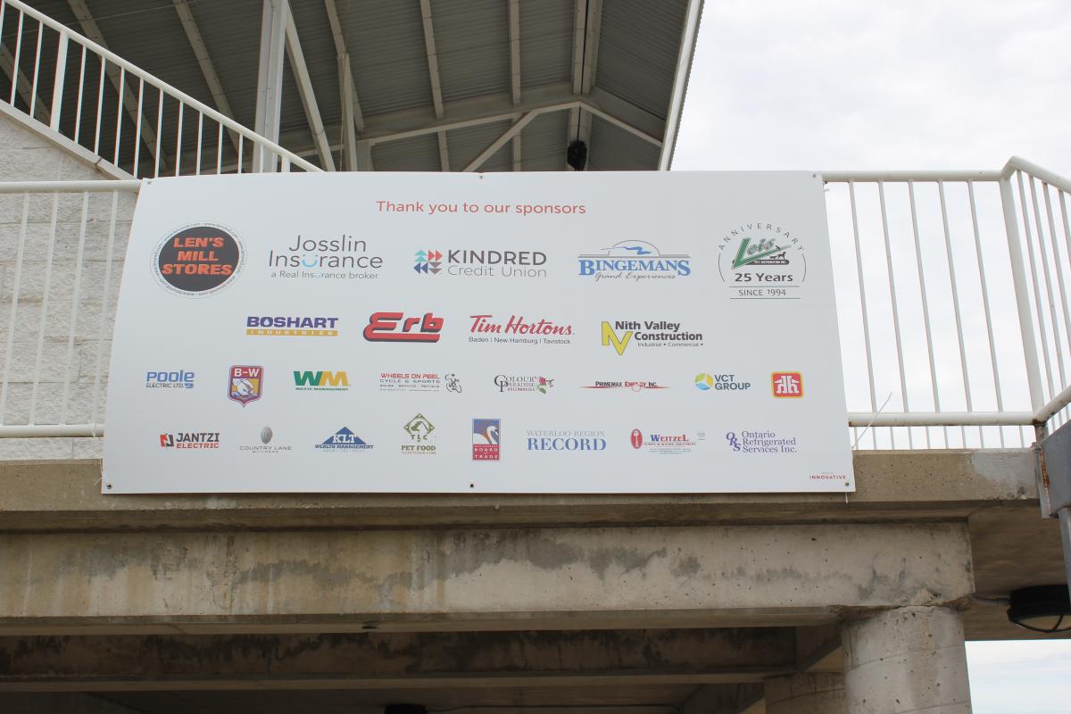 A sponsor banner overhangs a railing from a high platform