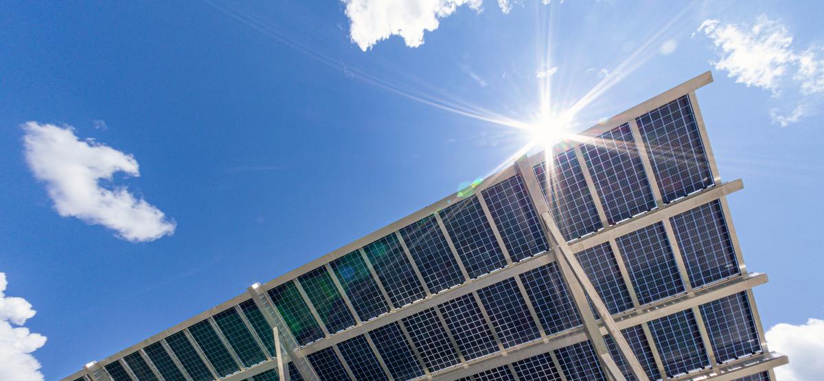 Underside of large solar panel against backdrop of blue sky